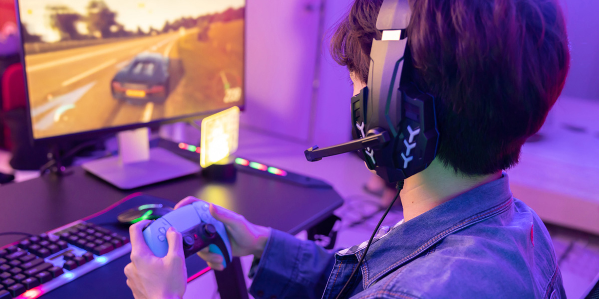 person wearing a gaming headset and holding a gaming controller